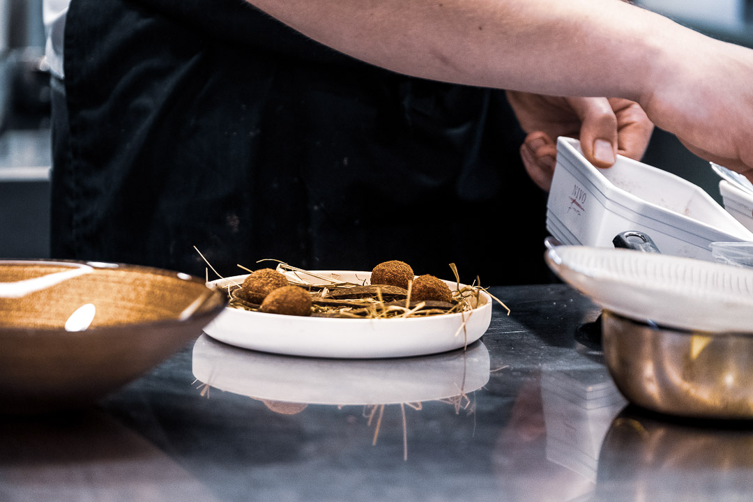 https://hungryformore.be/app/uploads/2024/12/de-jonkman-bruges-chef-plating-in-the-kitchen.jpg