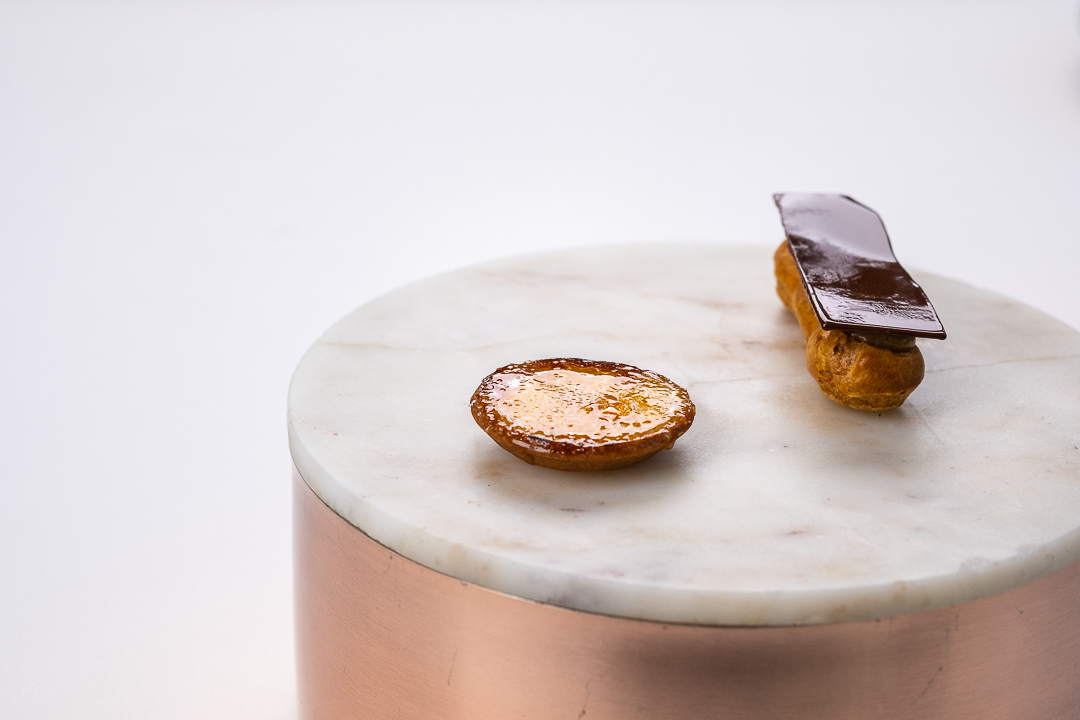 https://hungryformore.be/app/uploads/2024/12/de-jonkman-bruges-petit-fours-on-a-marble-stand.jpg