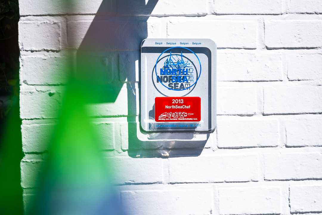 https://hungryformore.be/app/uploads/2024/12/de-jonkman-bruges-plaque-on-the-white-facade.jpg