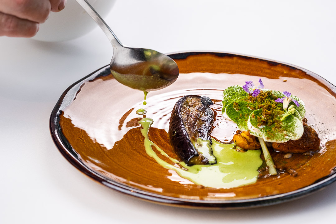https://hungryformore.be/app/uploads/2024/12/de-jonkman-bruges-sauce-being-spooned-over-a-fish-dish.jpg