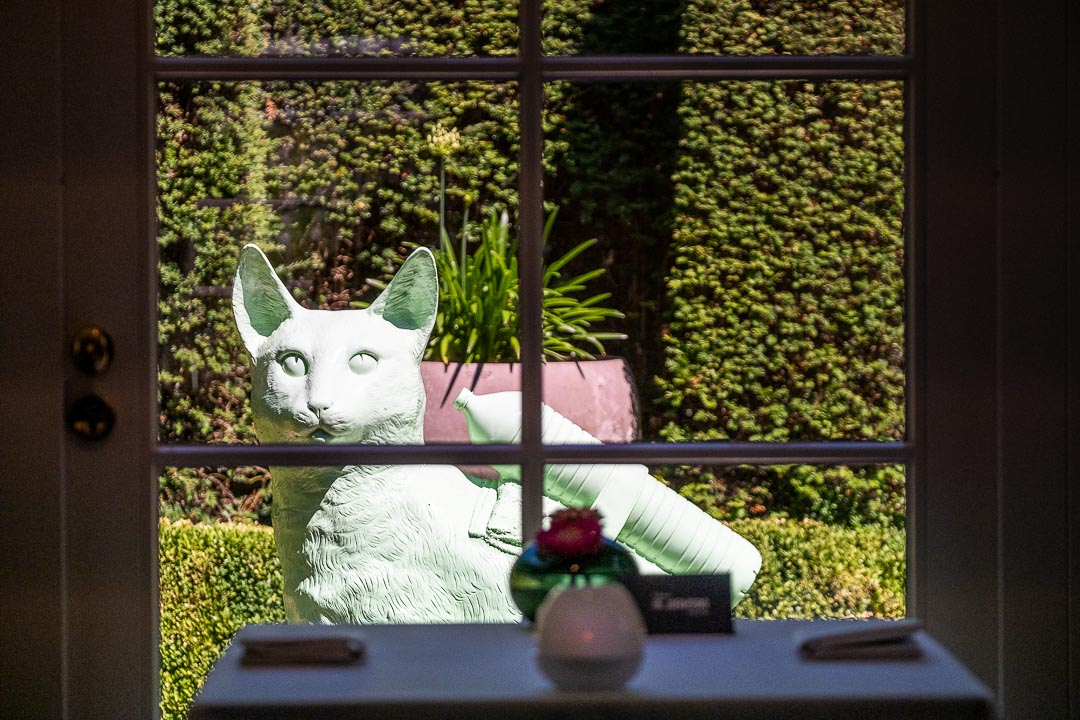 https://hungryformore.be/app/uploads/2024/12/de-jonkman-bruges-view-through-the-window-of-a-statue-in-the-garden.jpg