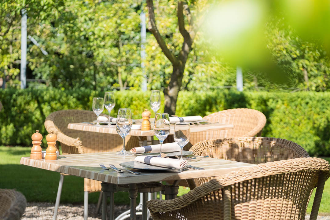 https://hungryformore.be/app/uploads/2024/12/grand-hotel-karel-v-utrecht-garden-terrace-with-wicker-chairs.jpg