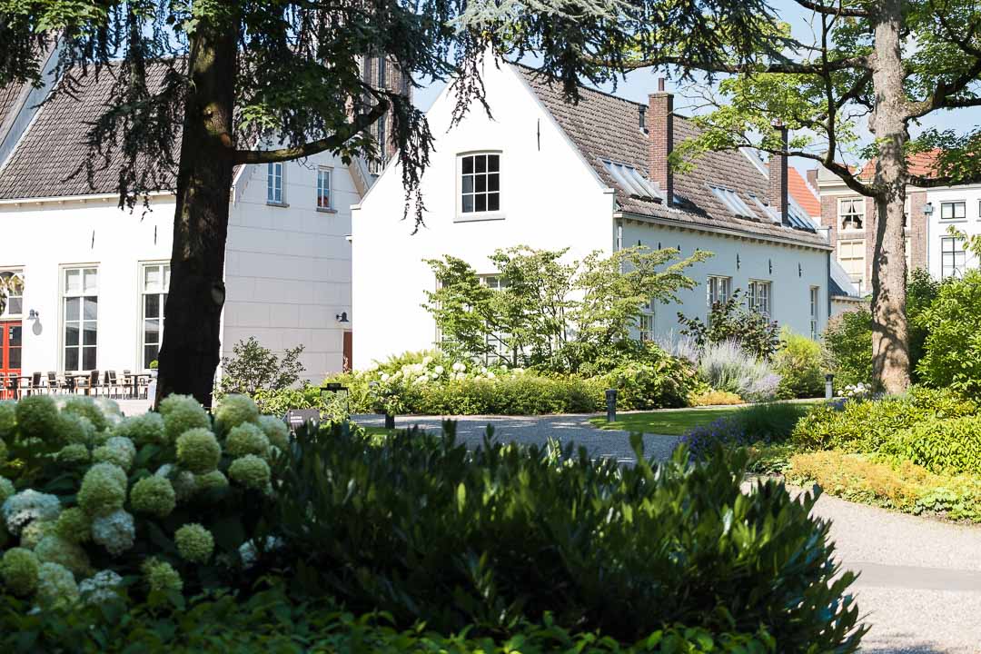 https://hungryformore.be/app/uploads/2024/12/grand-hotel-karel-v-utrecht-white-building-and-garden.jpg
