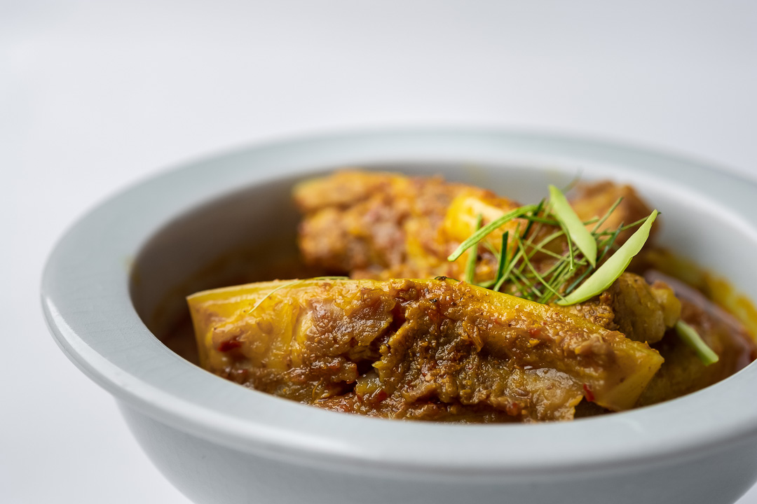 https://hungryformore.be/app/uploads/2024/12/sukhothai-bangkok-curry-in-a-white-bowl.jpg