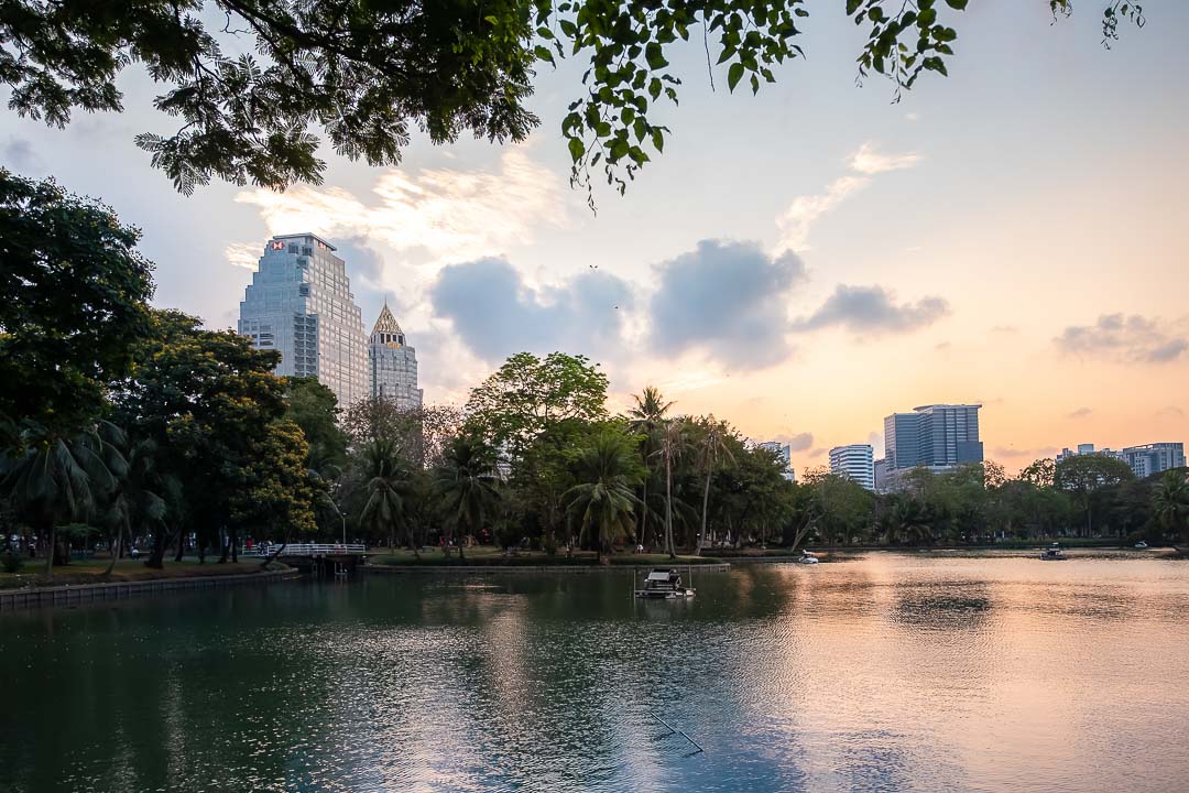 https://hungryformore.be/app/uploads/2024/12/sukhothai-bangkok-lumphini-park-lake-at-sunset.jpg