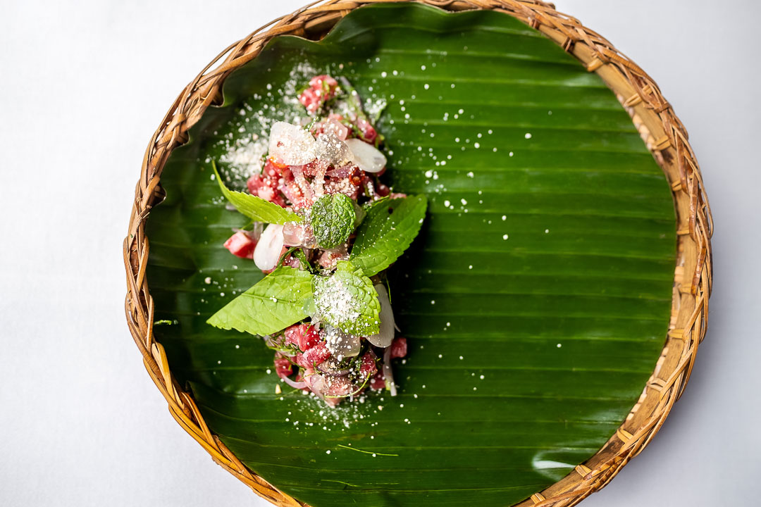 https://hungryformore.be/app/uploads/2024/12/sukhothai-bangkok-thai-dish-on-banana-leaf-in-a-basket.jpg