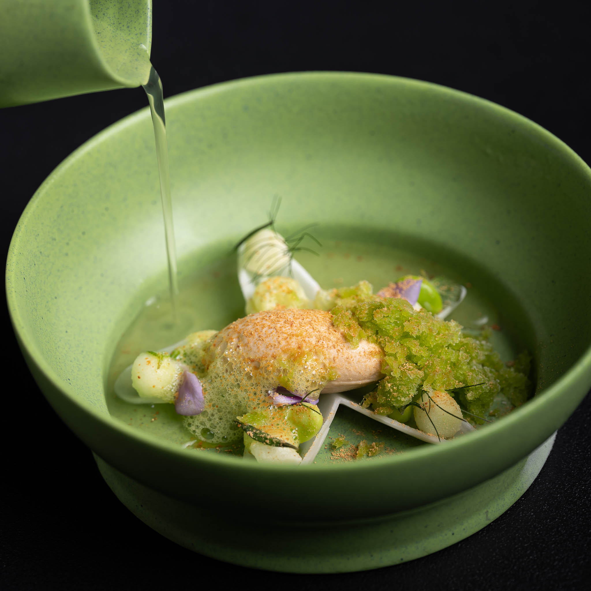 https://hungryformore.be/app/uploads/2025/01/pastorale-rumst-broth-being-poured-into-a-green-bowl.jpg