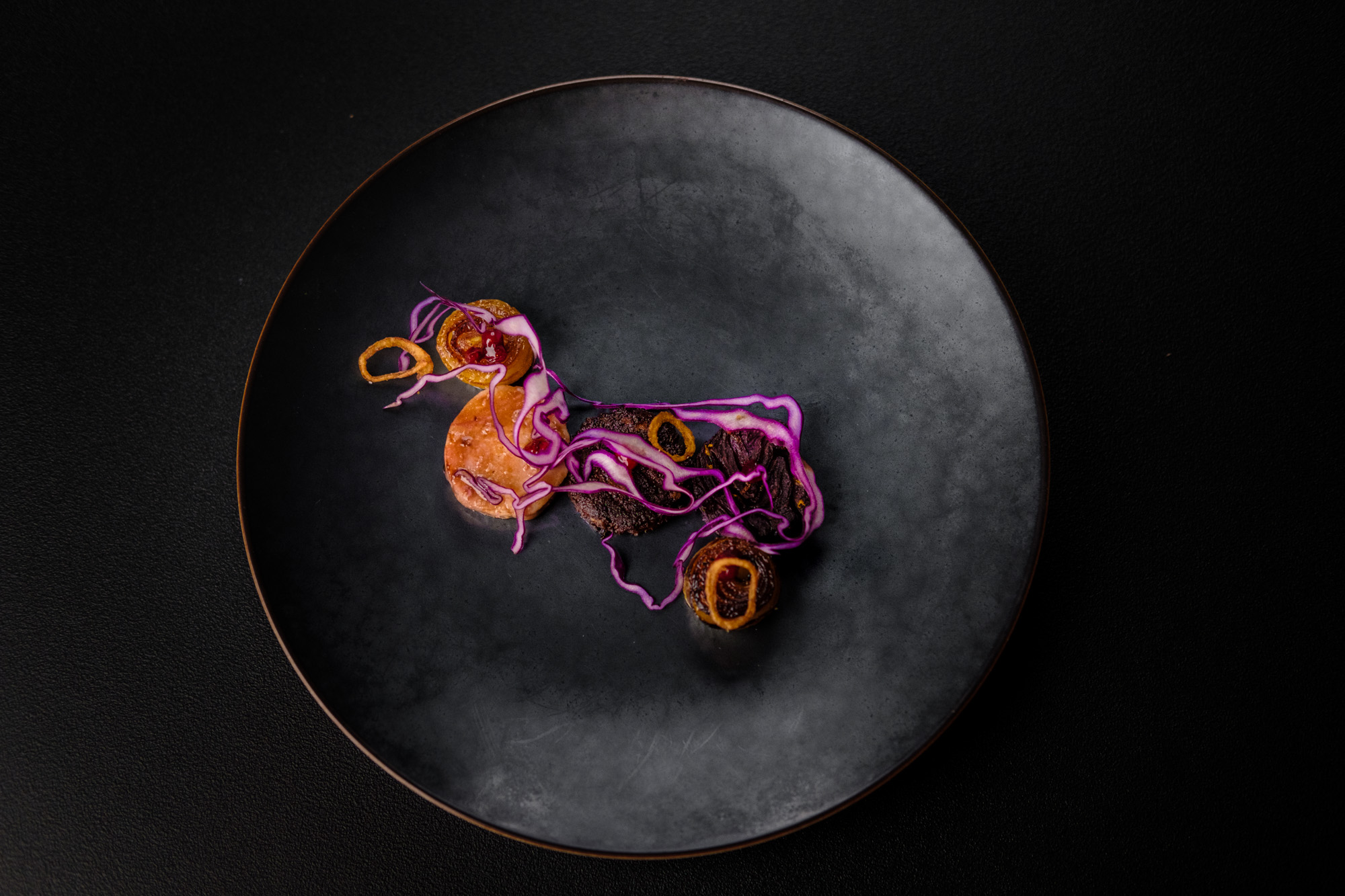 https://hungryformore.be/app/uploads/2025/01/pastorale-rumst-dish-with-red-cabbage-on-a-black-plate.jpg