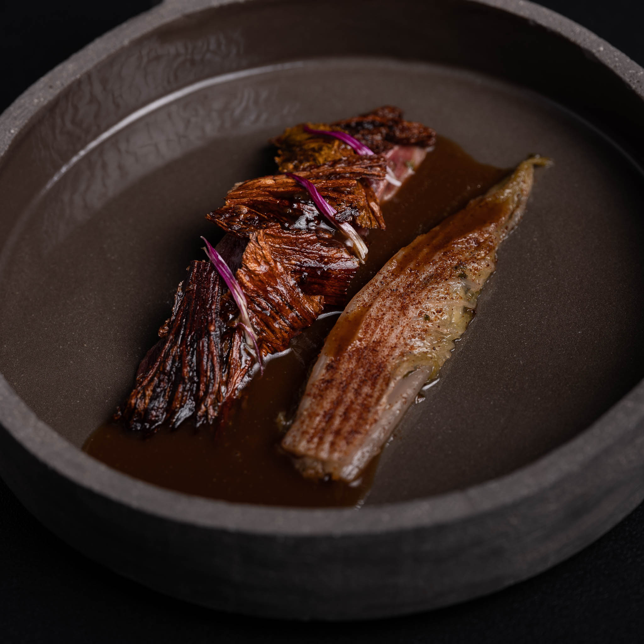 https://hungryformore.be/app/uploads/2025/01/pastorale-rumst-dish-with-roasted-leaves-in-a-dark-bowl.jpg