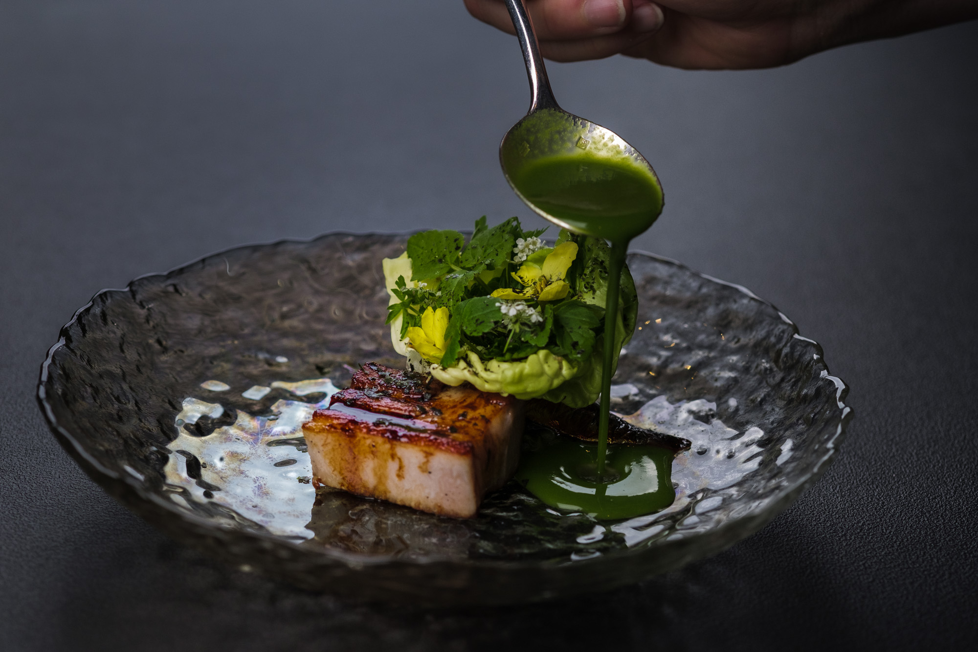 https://hungryformore.be/app/uploads/2025/01/pastorale-rumst-sauce-being-spooned-over-a-dish-with-greens.jpg