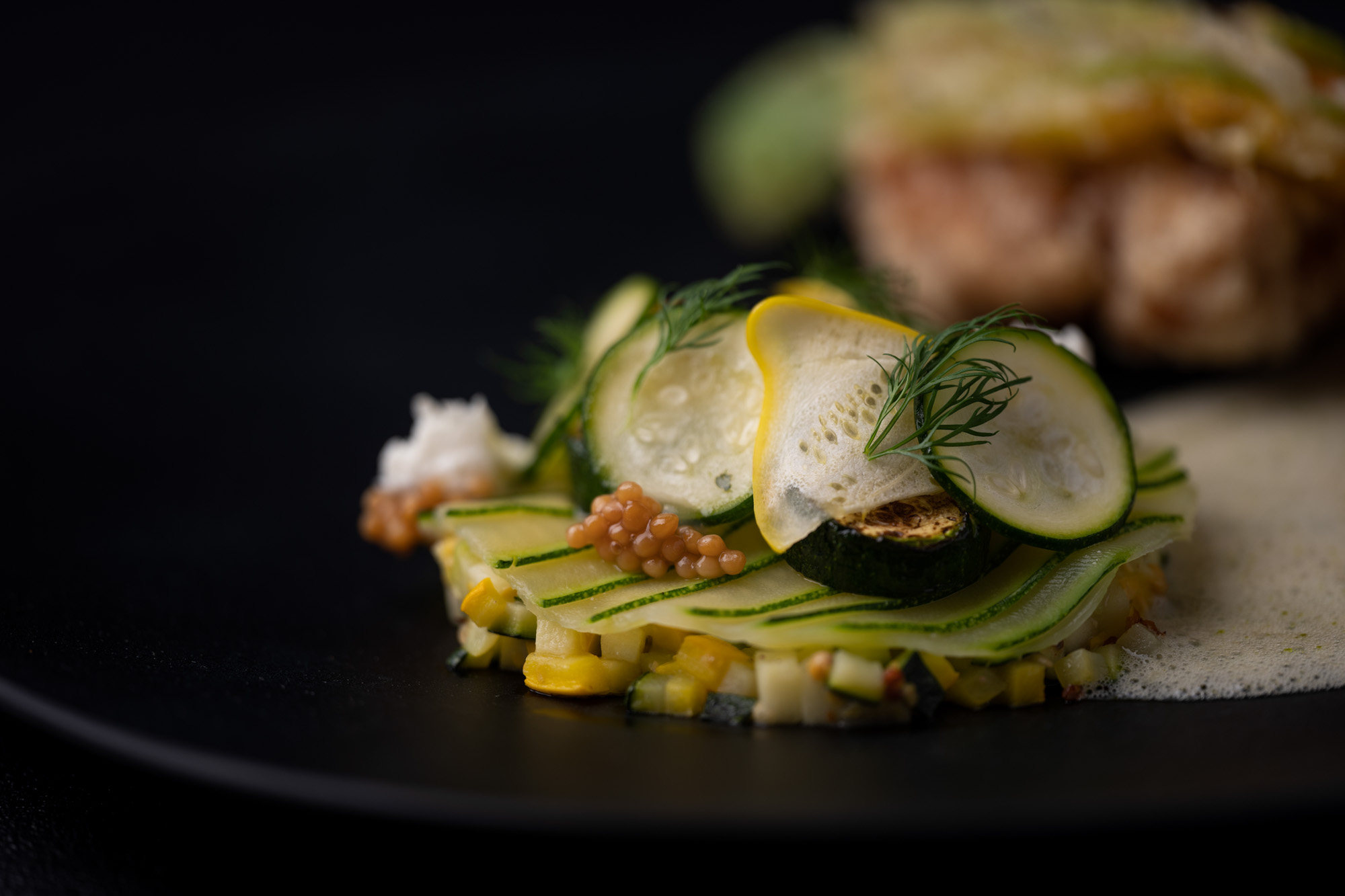 Vegetable dish with courgette on a black plate at restaurant Pastorale in Rumst